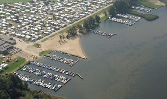 Overzichtsfoto van de haven, het strand en steigers langs de kust aan het Veluwemeer